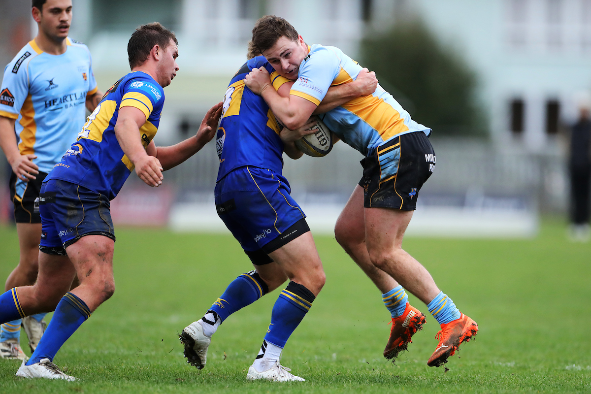 Ivan Hill of University is caught in a tackle during the premier club rugby match between Taieri and University played for the Paul Sapsford Memorial Trophy, played at Peter Johnstone Park in Dunedin on Saturday 14th May, 2022. © John Caswell / http://www.caswellimages.com